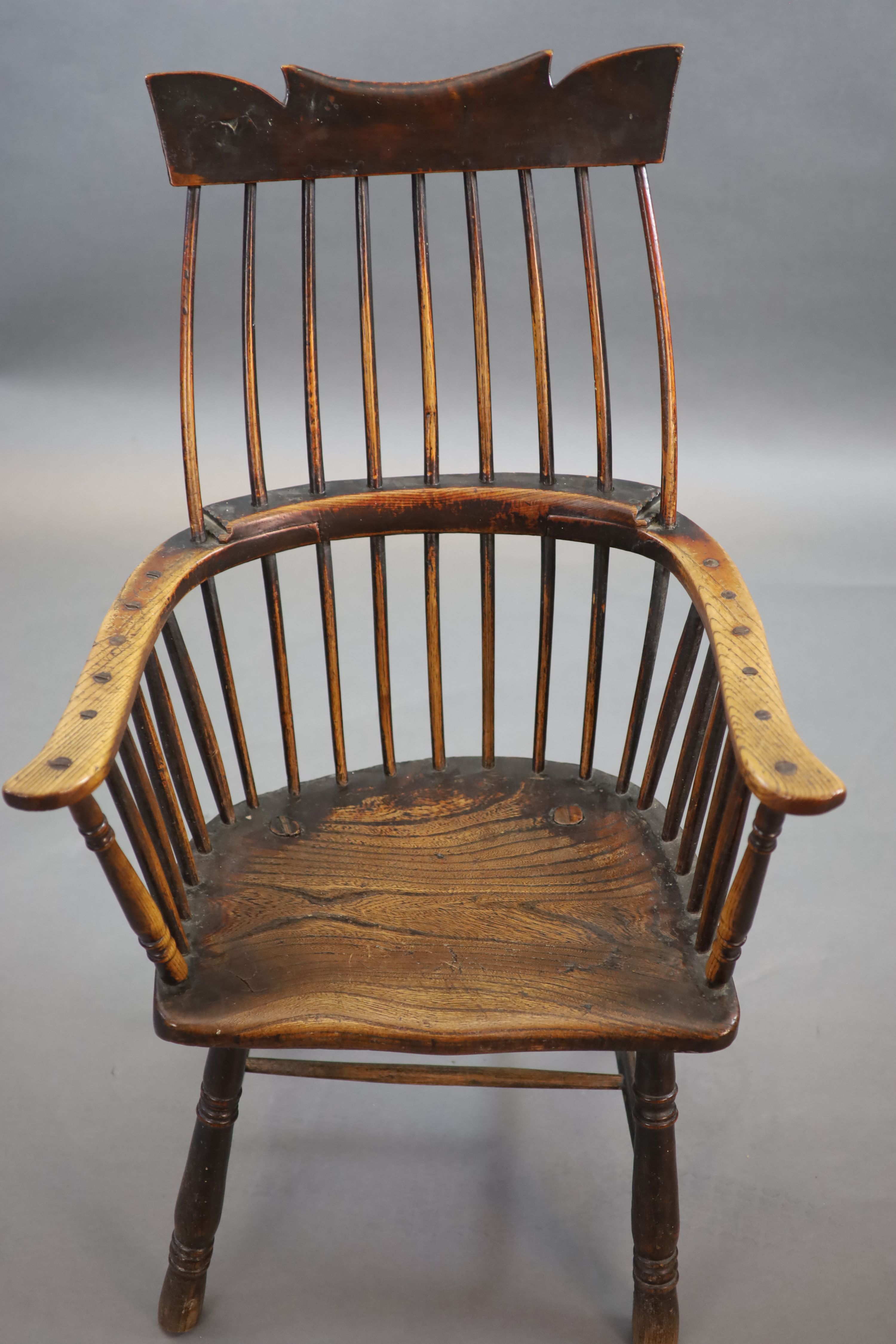 A primitive comb back Windsor armchair, possibly West Country, 67cm wide, 39cm deep, 106cm high.
